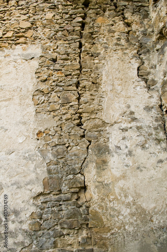 Cracked aged stone wall texture. Textured grunge wall surface background pattern of masonry of old medieval castle