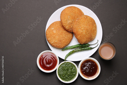 Indian snakes food kachouri or kachoudi kachori served with masala or cutting chai tamarind and mint chutney photo