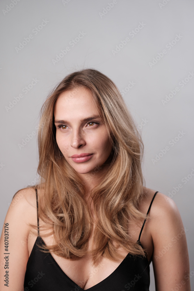 Portrait of a beautiful young girl on a gray background