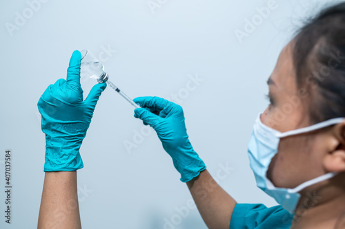Asian doctor with Syringe and vaccine for protect covid-19 virus on white background