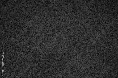 Dark grey decorative plaster on the facade of the building. Abstract grunge decorative stucco wall texture. Rough background with copy space for text. Beautifully stuccoed wall of house.