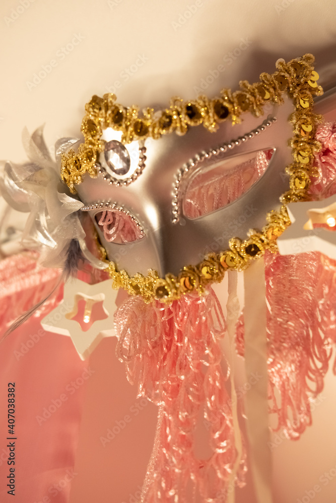 Gold and grey carnaval mask and rose curtains decorate girl's bed Gold and grey carnaval mask and rose curtains decorate girl's bed