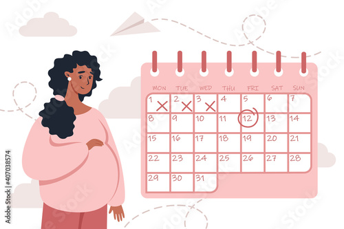 Happy pregnant woman stands near the calendar