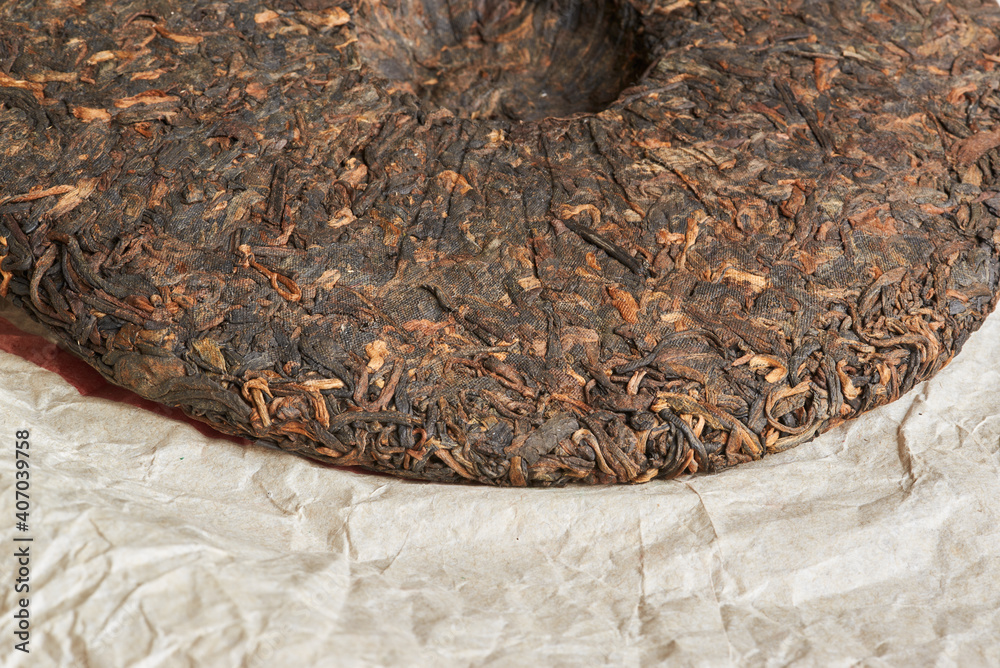 Naklejka premium Chinese pressed pu er tea on wrapping paper close-up