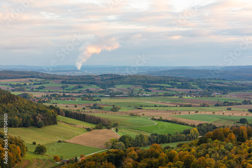 Kraftwerk mit Wasserdampfsäule aus dem Kühlturm in der Landschaft photo