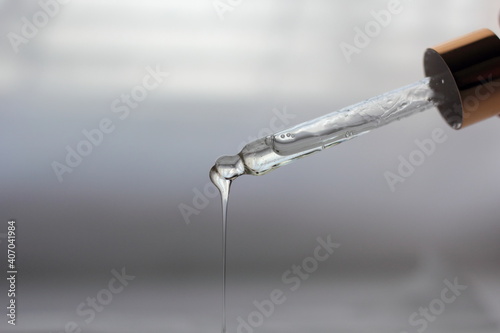 Closeup of a dropper with dripping castor oil.