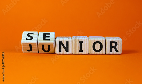 From junior to senior symbol. Turned cubes and changed the word 'junior' to 'senior'. Beautiful orange background, copy space. Business and junior or senior concept.