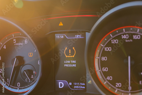 Low tire pressure error sign. Warning lights flash on the car dashboard. 