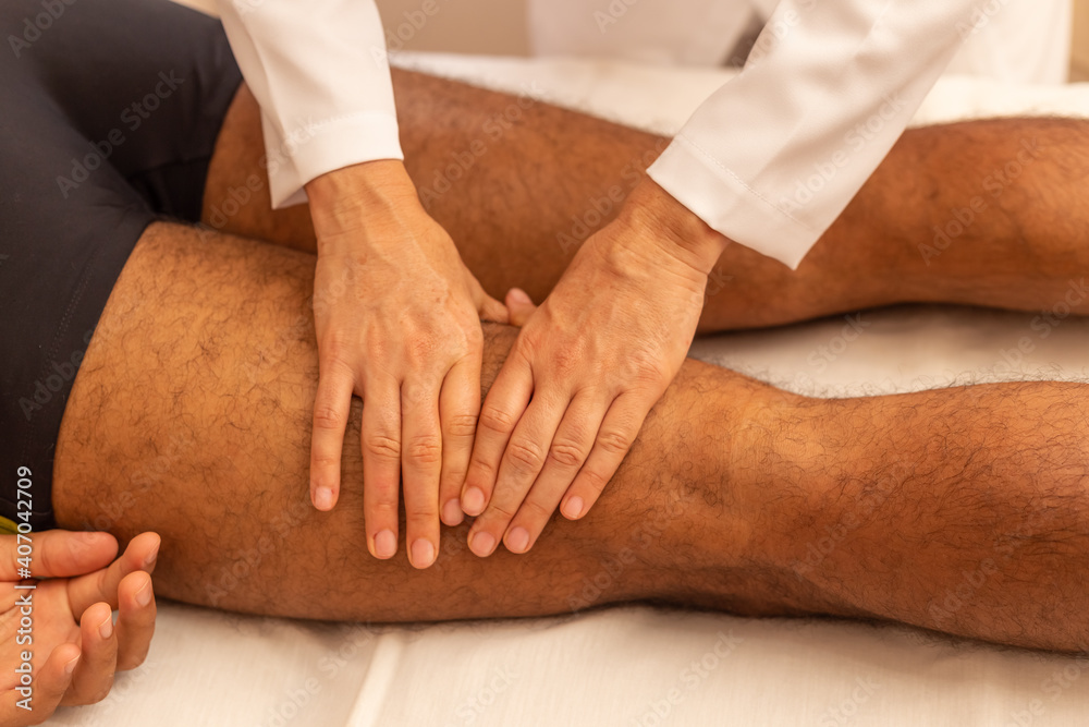 Mãos de terapeuta que está fazendo massagem em perna de paciente. Mãos de terapeuta que está fazendo massagem em perna de paciente.