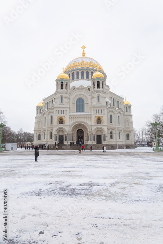 Monumental christian cathedral with people outside in winter.