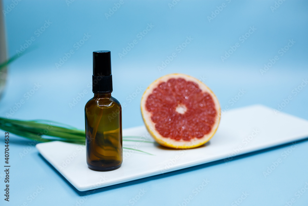 Transparent brown bottles for shampoo, soap or other cosmetics on a blue background with pieces of decor, grapefruit with space for text. salon therapy, brand layout, concept of minimalism.