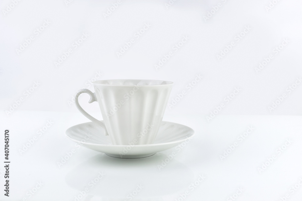White porcelain cup and saucer on white surface White porcelain cup and saucer on white surface