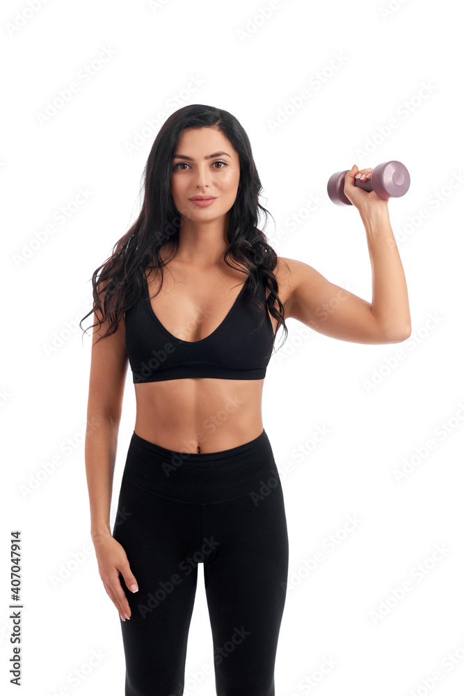 Sporty woman with dumbbell posing in studio Sporty woman with dumbbell posing in studio