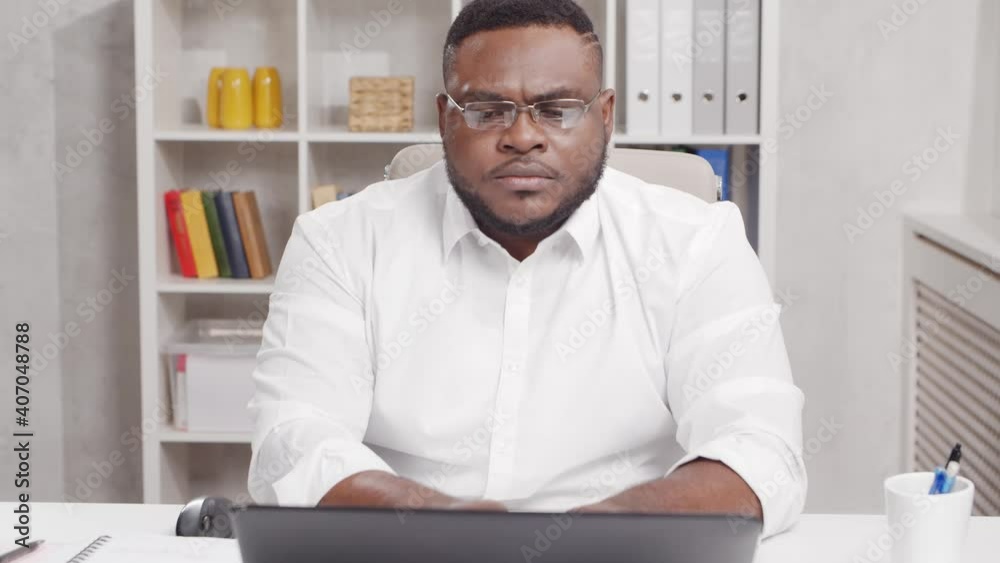 Workplace of freelance worker at home office. Young African-American man works using computer. Remote job concept. Workplace of freelance worker at home office. Young African-American man works using computer. Remote job concept.
