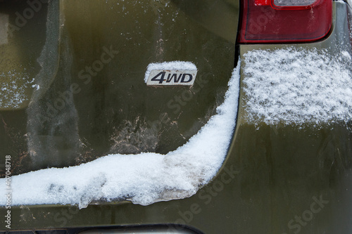an abbreviation 4wd - Four-wheel drive - on dirty green car back