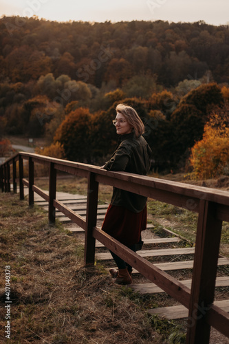 Young beautiful woman having a walk outdoors on golden our autumn. Lifestyle concept
