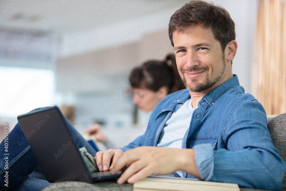 young attractive smiling guy is browsing on his laptop young attractive smiling guy is browsing on his laptop