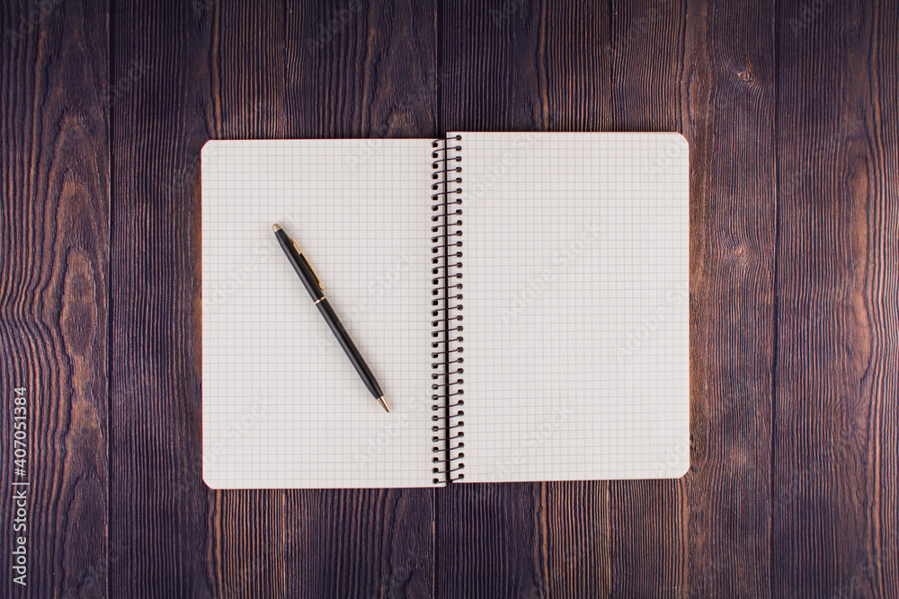 notebook with pen on a wooden table