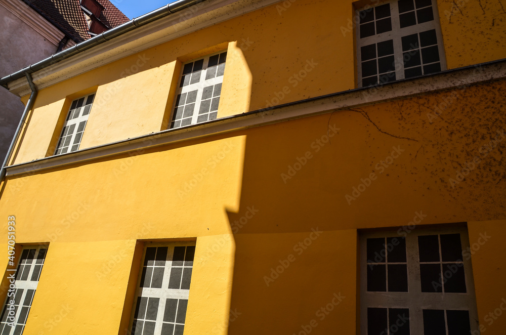 Yellow wall of a house with false windows in old town of Riga, Latvia