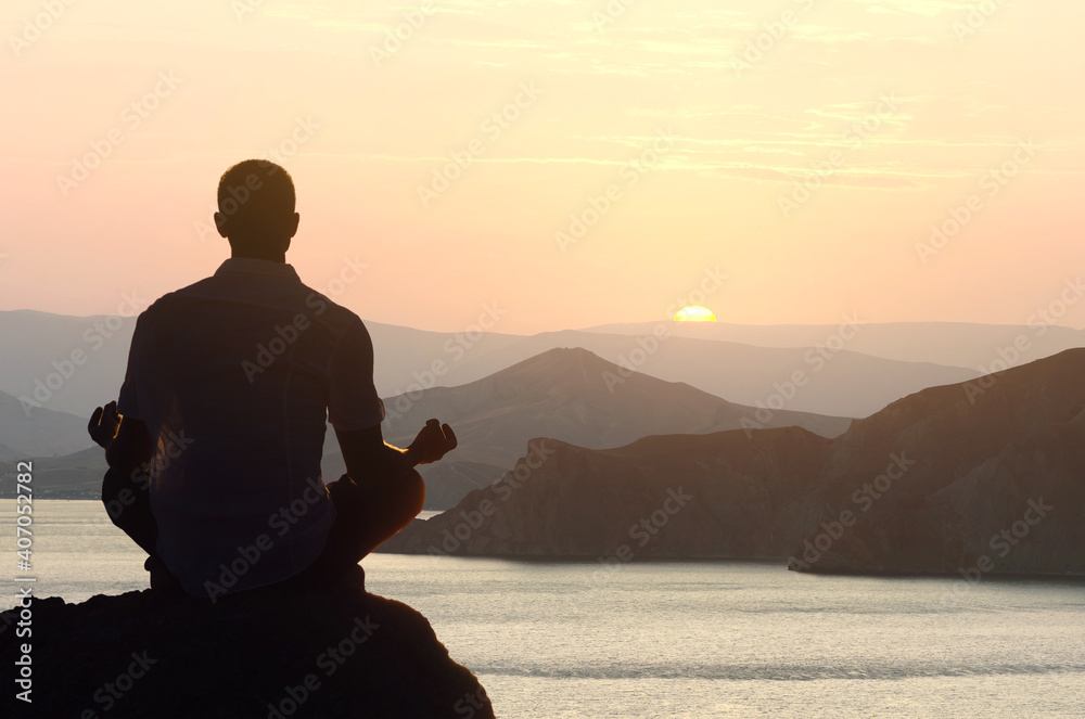 Man meditates at dawn in the lotus position