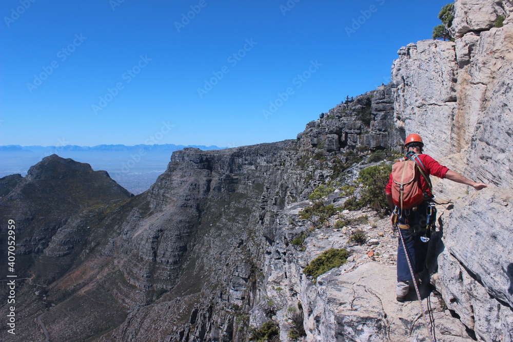 A daring European tourist rock climbing in Cape Town South Africa with all gears