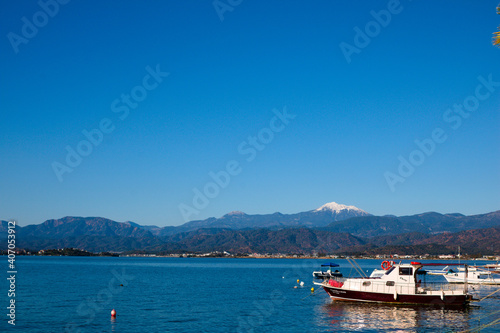 Blue sky, blue sea and small fishing boat on the shore.