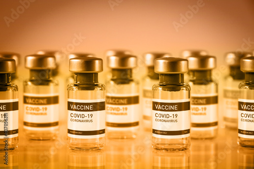 Covid-19 vaccine bottles on a yellow background