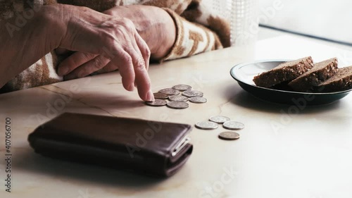 Hands of an elderly poor woman counting money, close-up