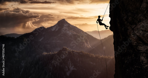 Silhouette Rappelling from Cliff. Beautiful aerial view of the mountains during a colorful and vibrant sunset or sunrise. Landscape taken in British Columbia, Canada. composite. Concept: Adventure © edb3_16