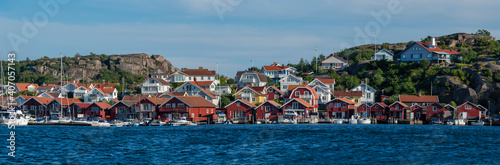 Colorful facades of Swedish summerhouse and sailing boats in harbour