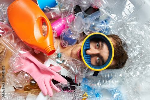 man drowning under plastic recipients pile, garbage, used packs filling world ocean killing people. ecology, environment concept, plastic and glass pollution, nature disaster pollution photo