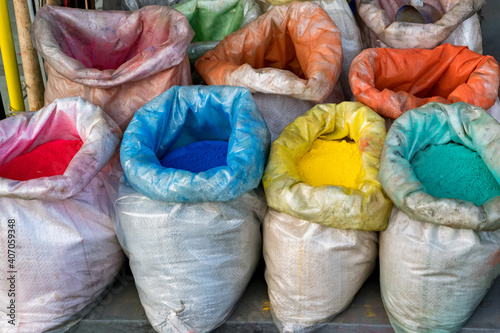 Close up colored bright color pigments in bags on street market © Yakov