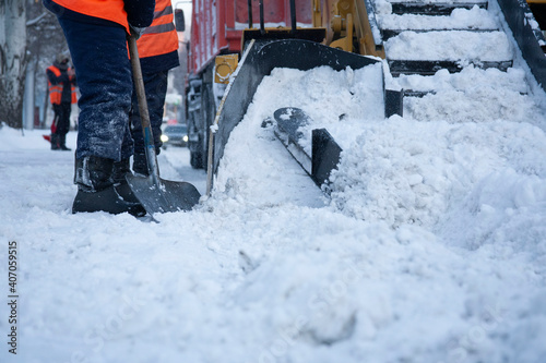 Workers remove snow from the sidewalks. Russian Winter. Snow removal.
