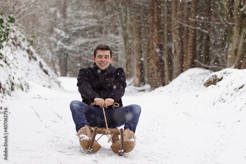 Man riding a sleigh, having fun and laughing - Winter time & sledge fun