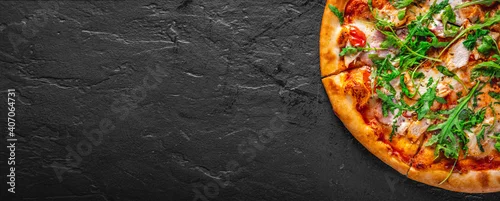 Obraz  z motywem Pizza with chicken, bacon, cheese, tomato and arugula. Italian pizza on Dark grey black slate background