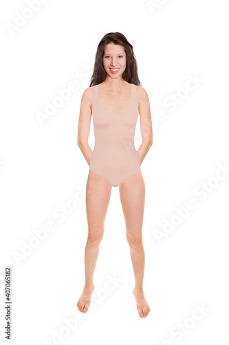 Full length portrait of a beautiful cheerful woman wearing a beige swimsuit, studio photo isolated in front of white background