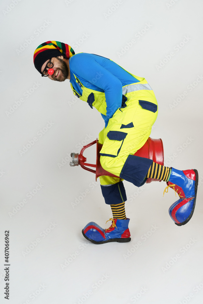 The clown fireman holds a fire barrel between his legs. The clown fireman holds a fire barrel between his legs.