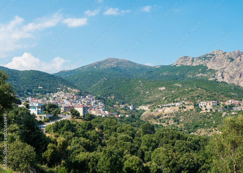 Aerial View of village Villagrande Strisaili with limestone rocks, mountains and green forest vegetation. Summer sunny day. Province of Nuoro, Sardinia, Italy, Europe