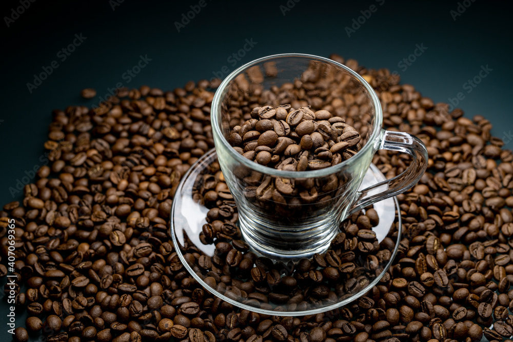 Fototapeta premium a cup of coffee among roasted coffee beans