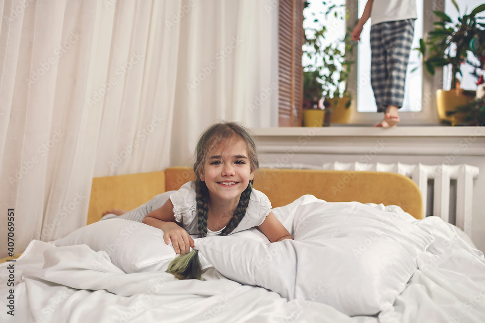 Happy little in pajama relaxing in bed in the morning, healthy sleeping, invest in rest concept Happy little in pajama relaxing in bed in the morning, healthy sleeping, invest in rest concept