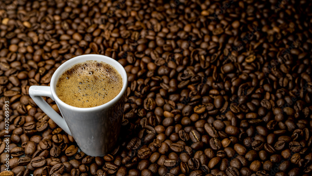 a cup of coffee among roasted coffee beans
a cup of coffee among roasted coffee beans