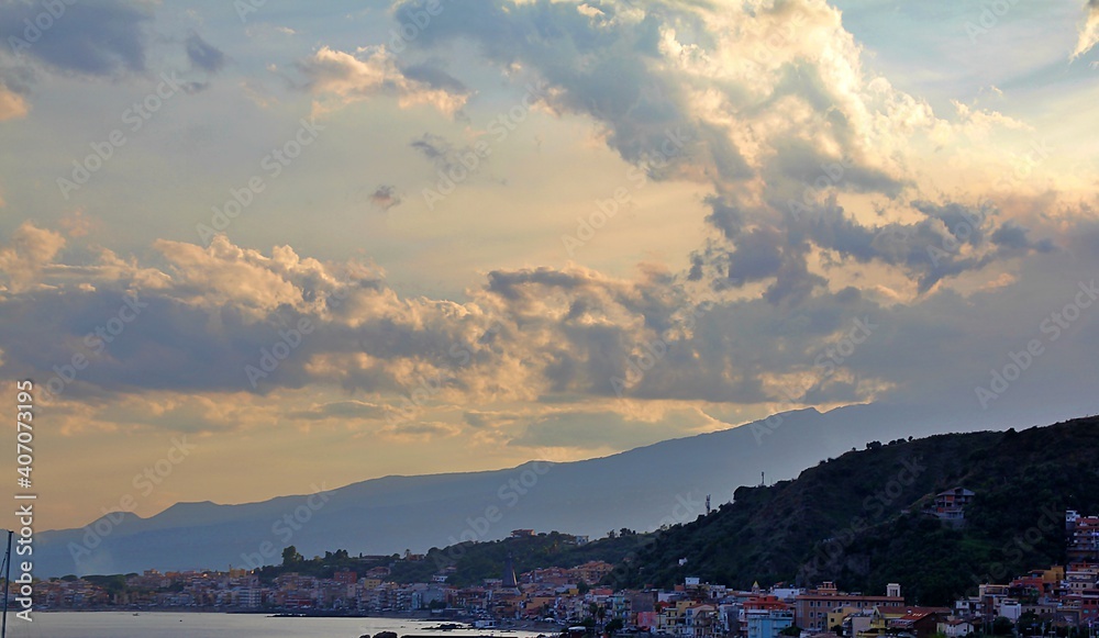 view of the bay, the mountains, the town under the mountains and by the sea, the beach and clouds with shining light