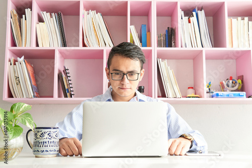 Fotografía Young man working in office in front of the computer on his desk in the morning