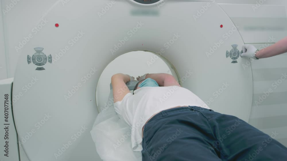 Doctor makes an MRI scan for a patient in a clinic. The male lies in the MRI device. Modern technologies in medicine. Examines lungs. Computed tomography during a coronavirus or covid pandemic. Doctor makes an MRI scan for a patient in a clinic. The male lies in the MRI device. Modern technologies in medicine. Examines lungs. Computed tomography during a coronavirus or covid pandemic.