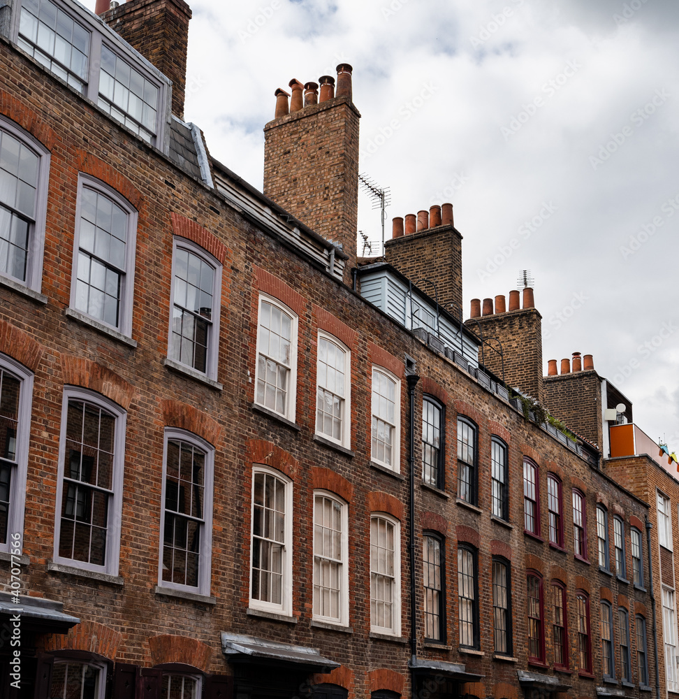 Row of typical London houses with brick wall