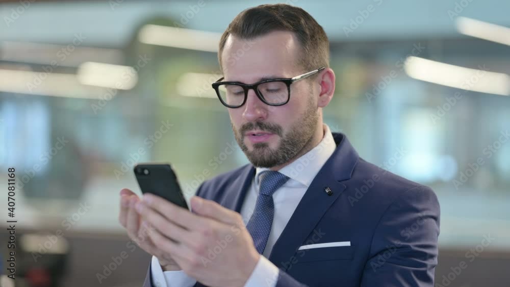 Disappointed Businessman Reacting to Loss on Smartphone Disappointed Businessman Reacting to Loss on Smartphone