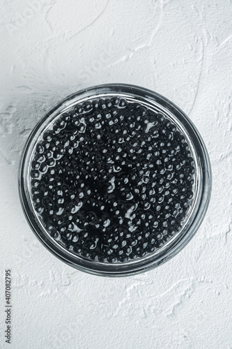 Black sturgeon caviar, on white background, top view flat lay