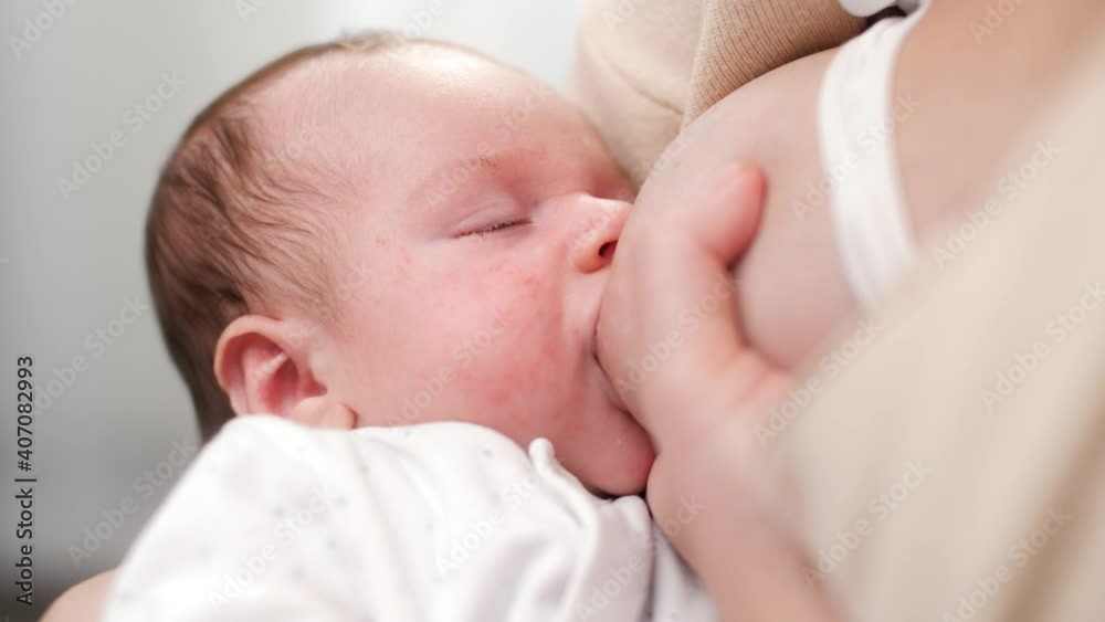 Portrait of adorable newborn baby falling asleep while eating mother's breast milk. Concept of healthy and natural baby breastfeeding nutrition. Portrait of adorable newborn baby falling asleep while eating mother's breast milk. Concept of healthy and natural baby breastfeeding nutrition.