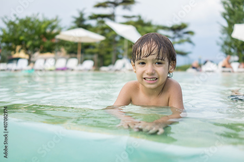 Cute little boy kid child splashing in swimming pool having fun leisure activity © Jasmin Merdan