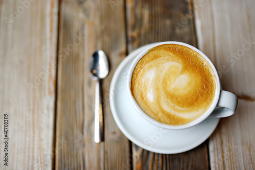 A cup of fresh cappuccino coffee on a wooden table in a cafe or restaurant. Coffee break.